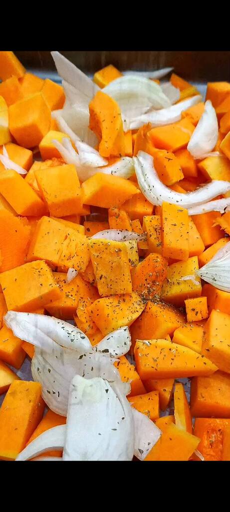 Season pumpkin and onions with oil, spices, and herbs