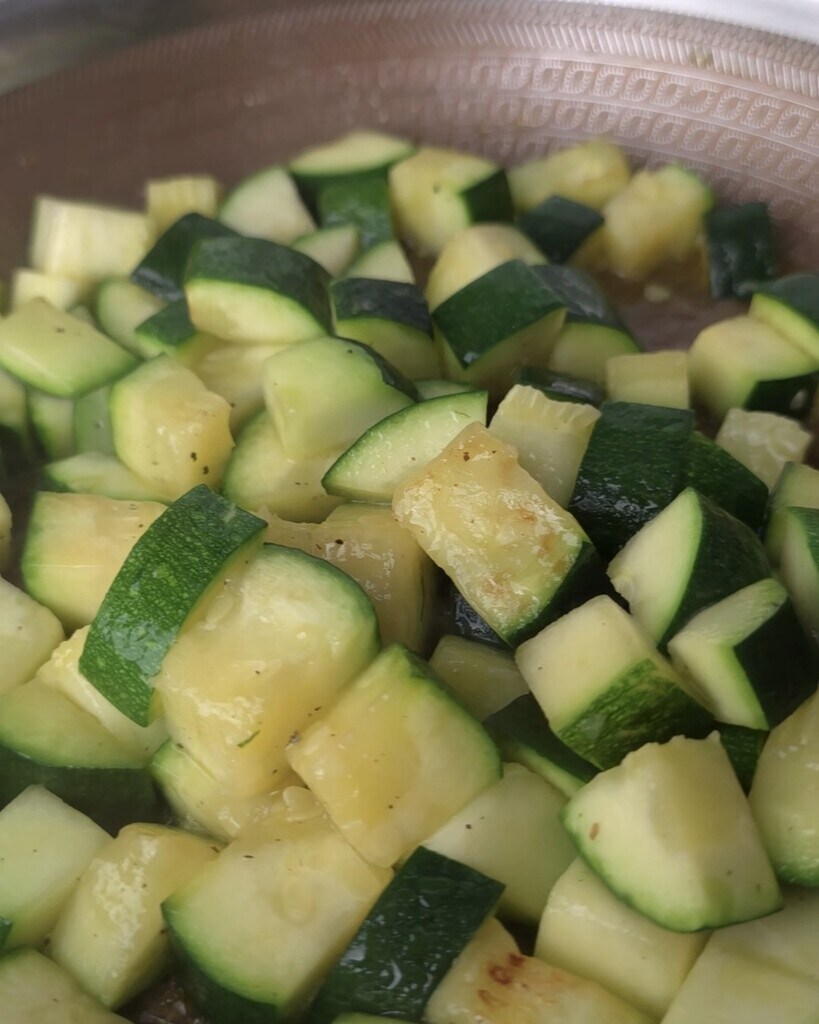 zucchini in a pan with oil and garlic