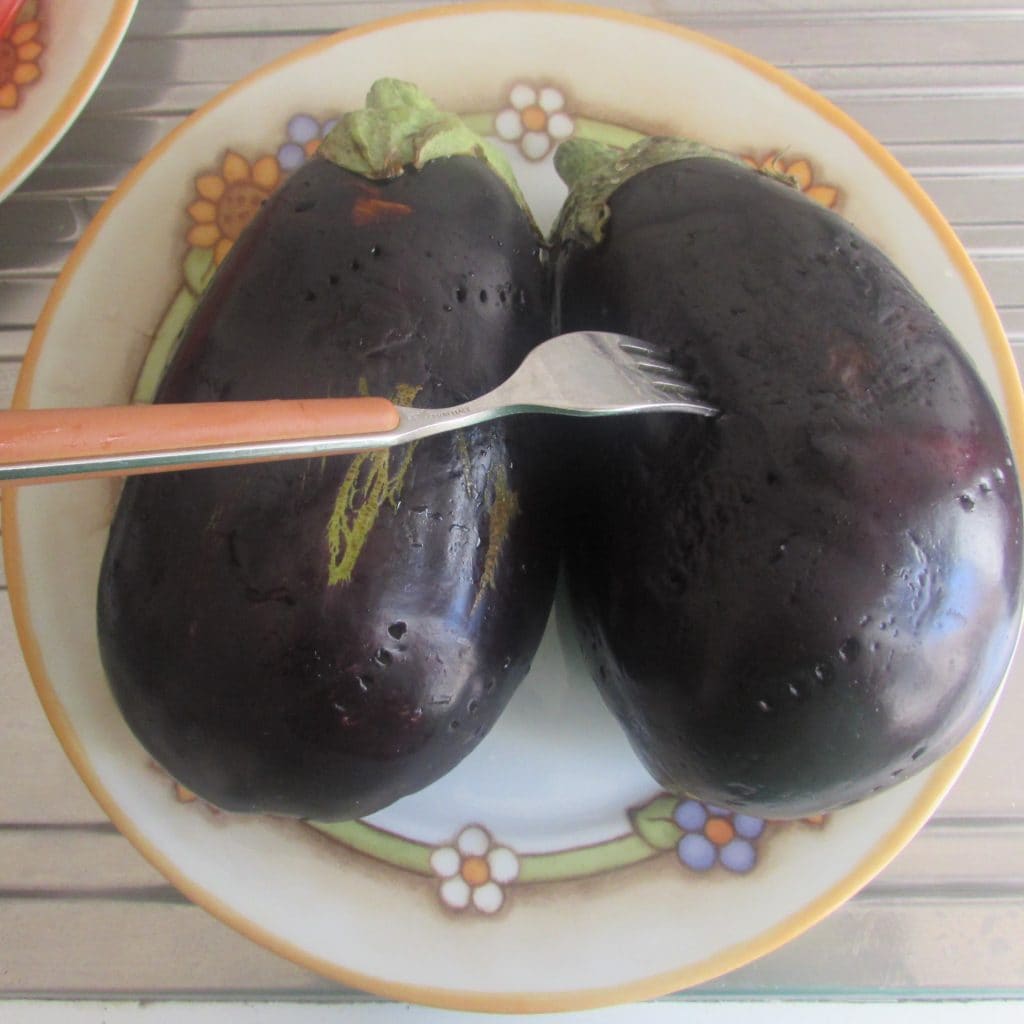 piercing the eggplants to cook them in the microwave