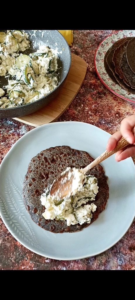 Filling each crepe with ricotta and zucchini