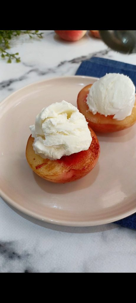 Place a scoop of ice cream on each peach