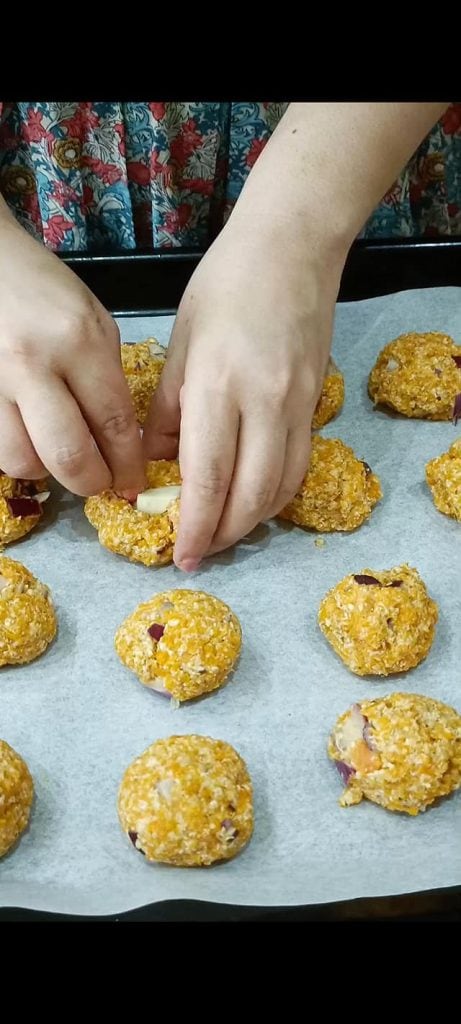 Filling each meatball with a cheese cube