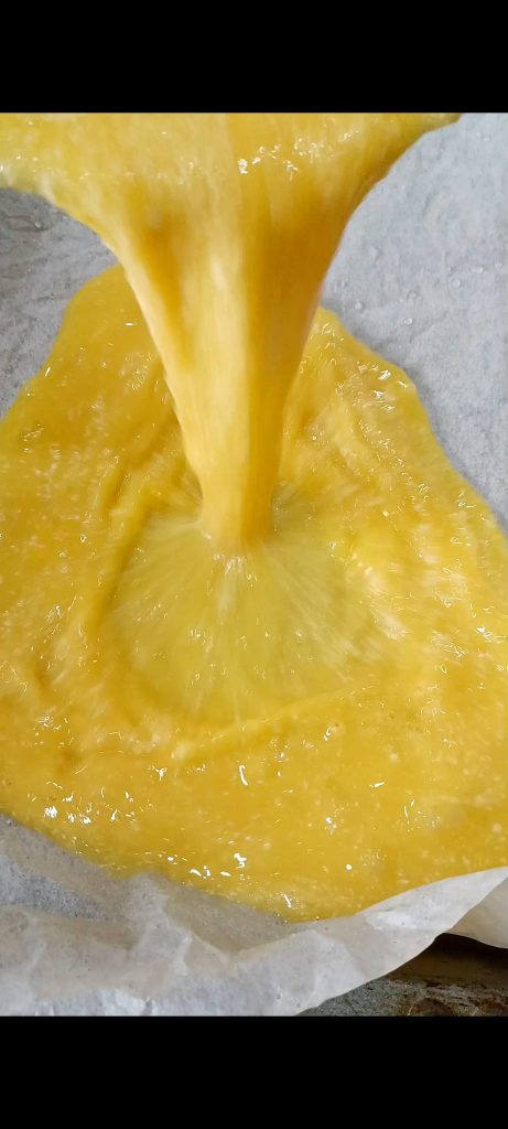 Eggs poured into a baking pan with parchment paper