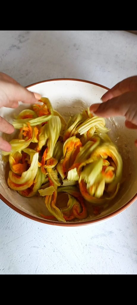 Add zucchini flowers to the batter