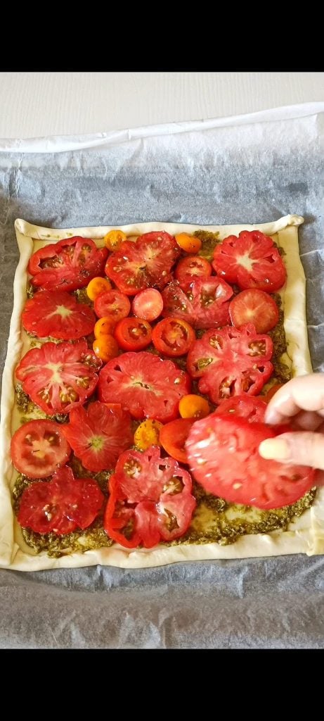 We arrange the tomatoes on the puff pastry and pesto