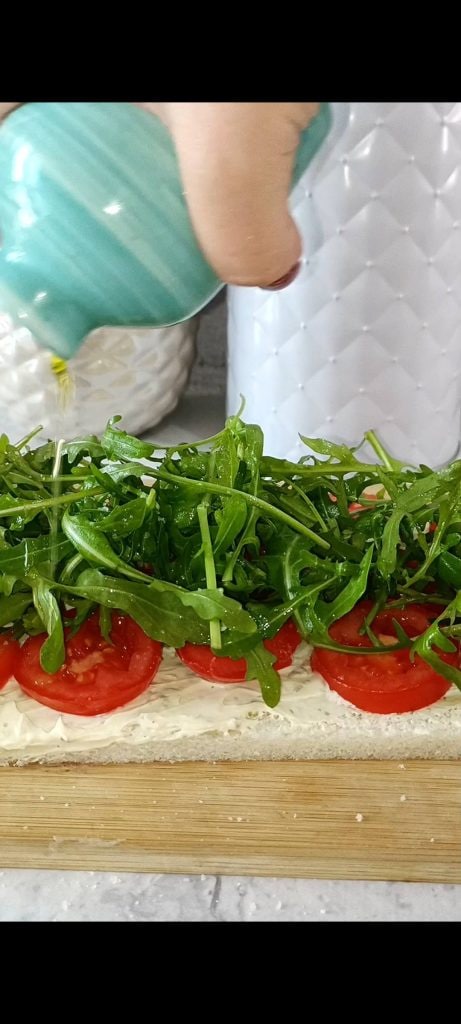 Spreadable cheese, tomatoes, and arugula