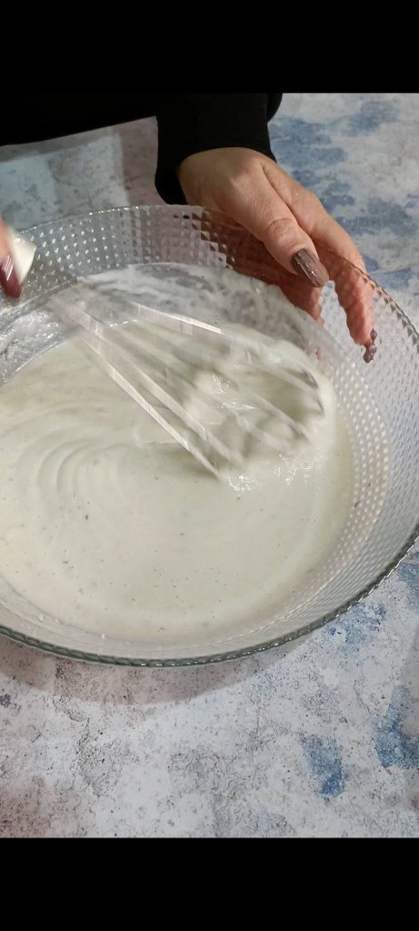 Making a batter with flour, water, oregano, salt, and pepper