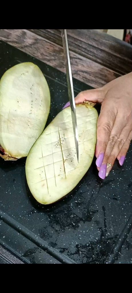 We cut the eggplants in half and score them