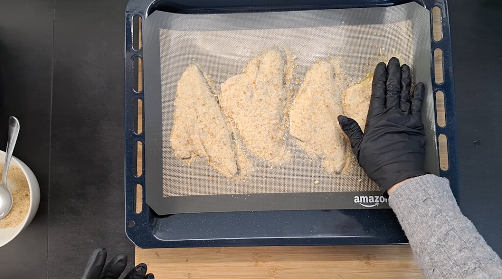 Pressing the breadcrumbs onto the sea bream fillets