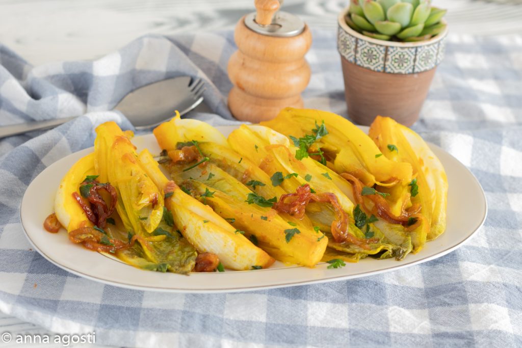 Belgian endive with curry in a pan