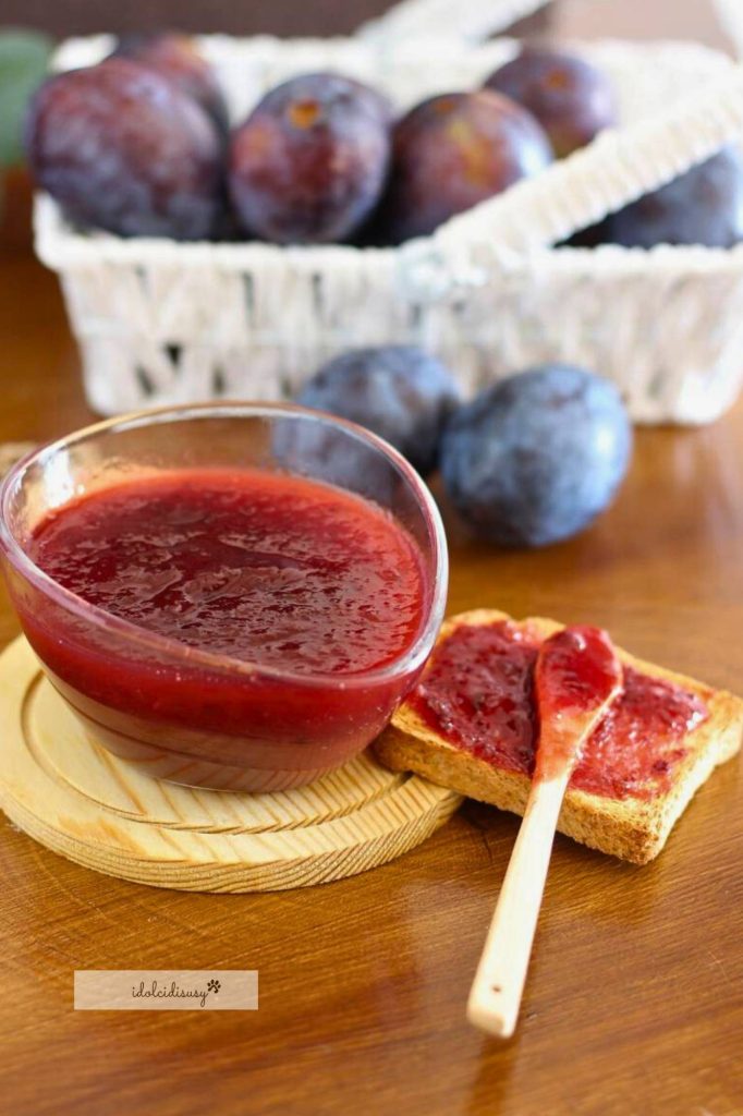 Homemade plum jam served on toasted slice with wooden spoon