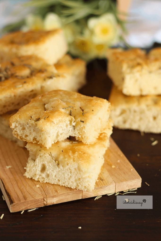 Slice of tall and soft white focaccia with rosemary, very soft inside
