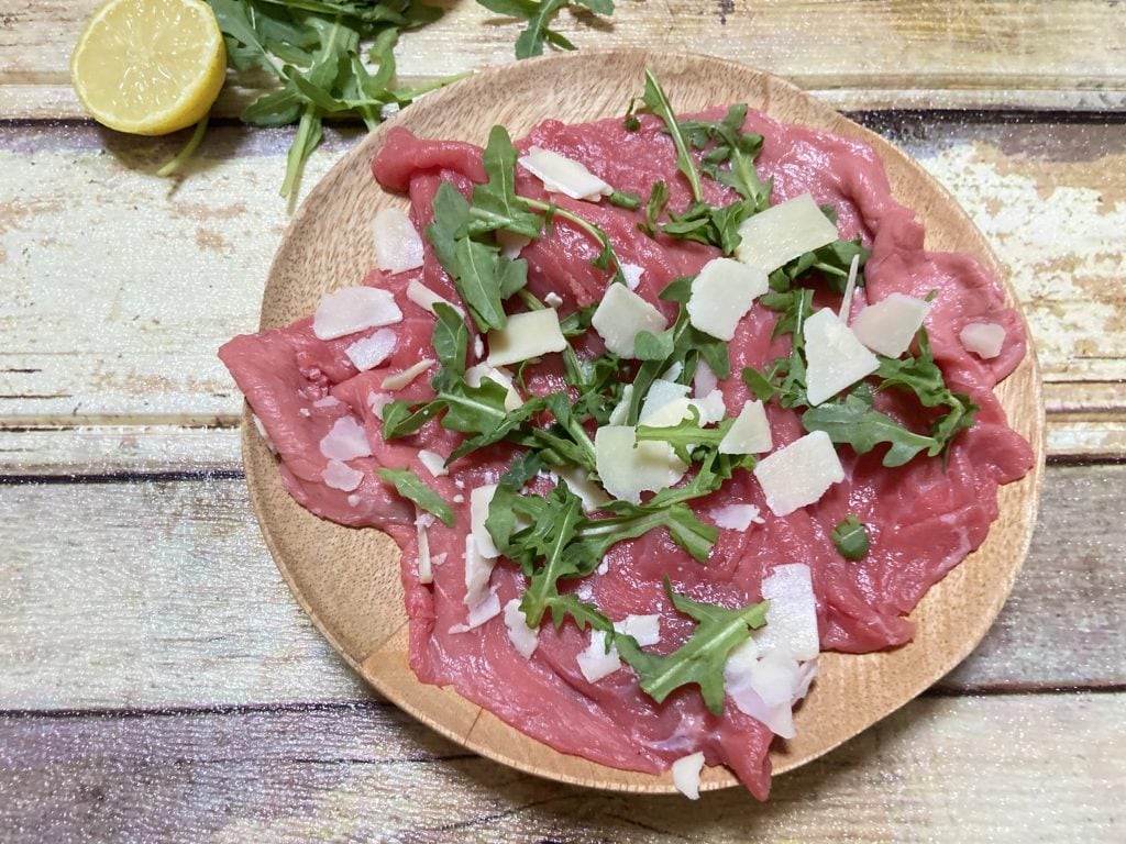 raw meat with arugula and Parmesan