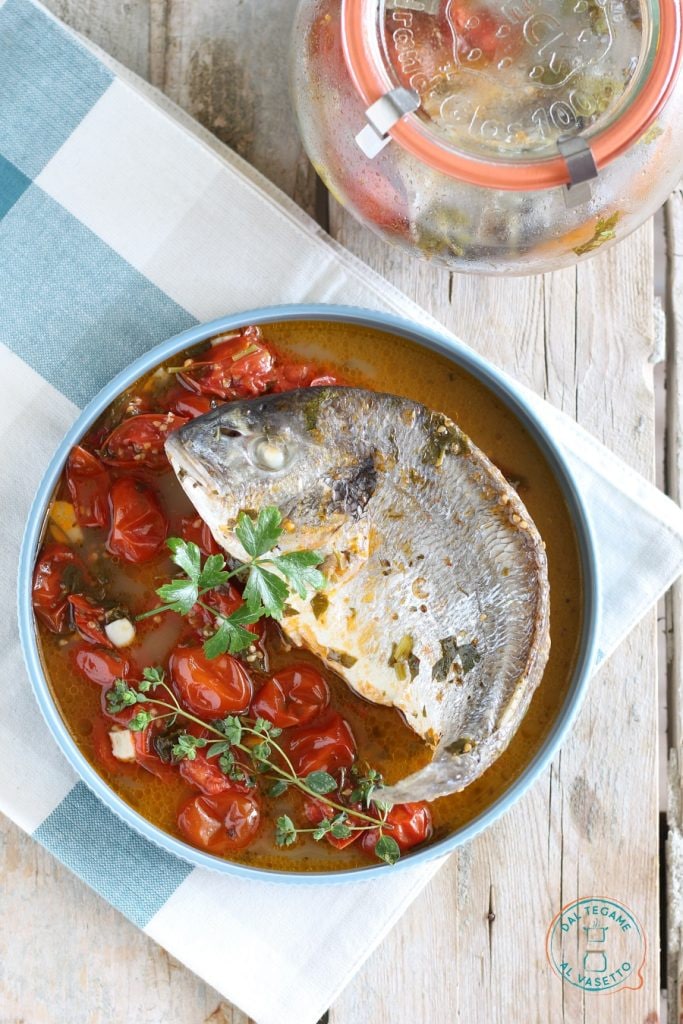 Whole sea bream with cherry tomatoes, garlic, and herbs cooked in jar cooking in the microwave