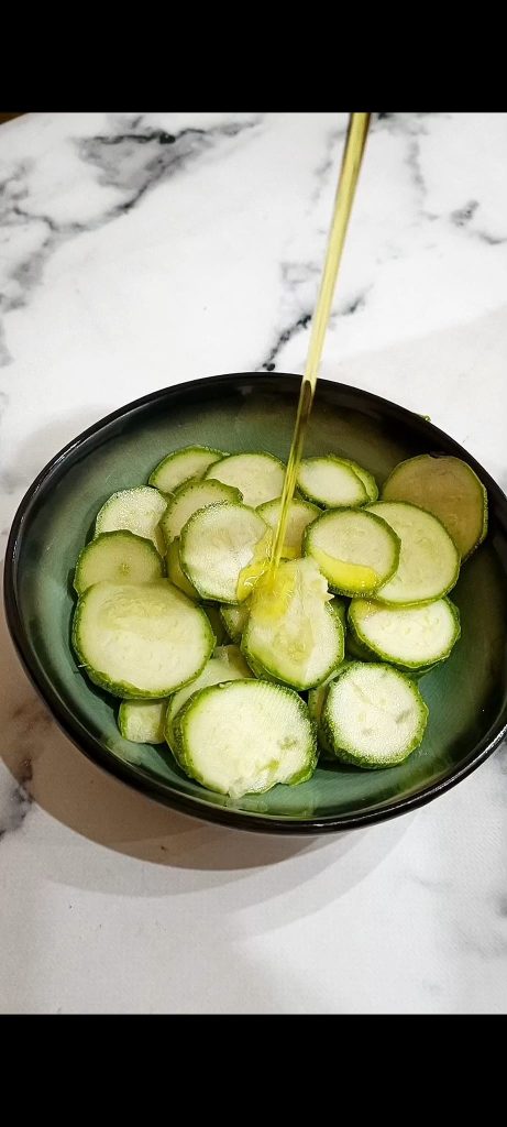 Sliced zucchini with oil on green plate