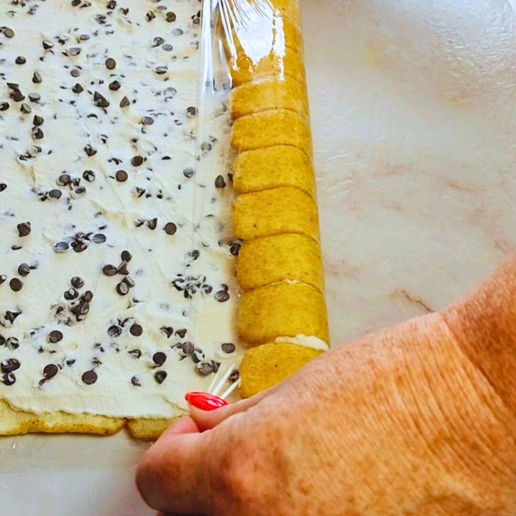 Ladyfingers with cream and chocolate chips rolled to form the tiramisu roll