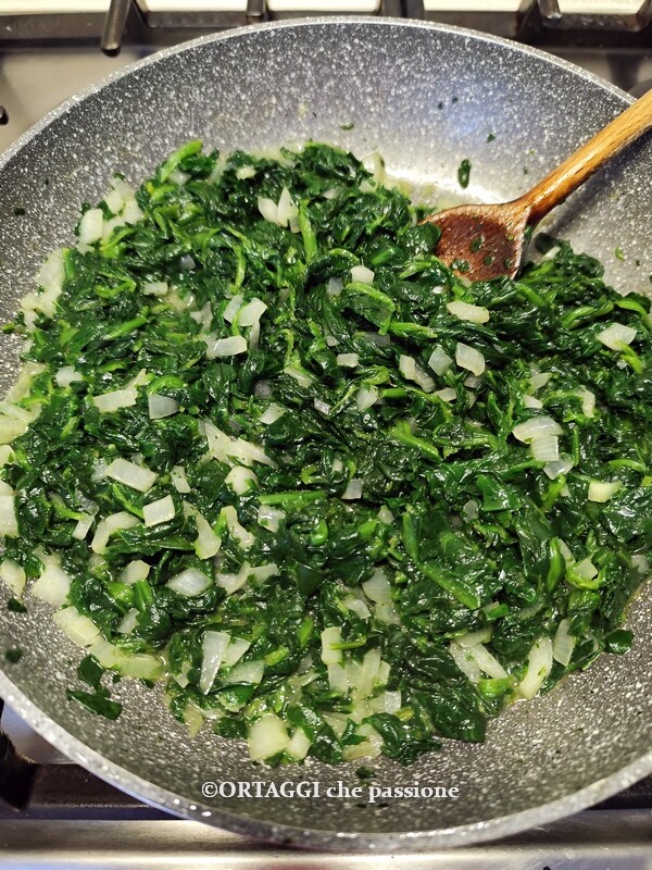 onions and spinach in a pan