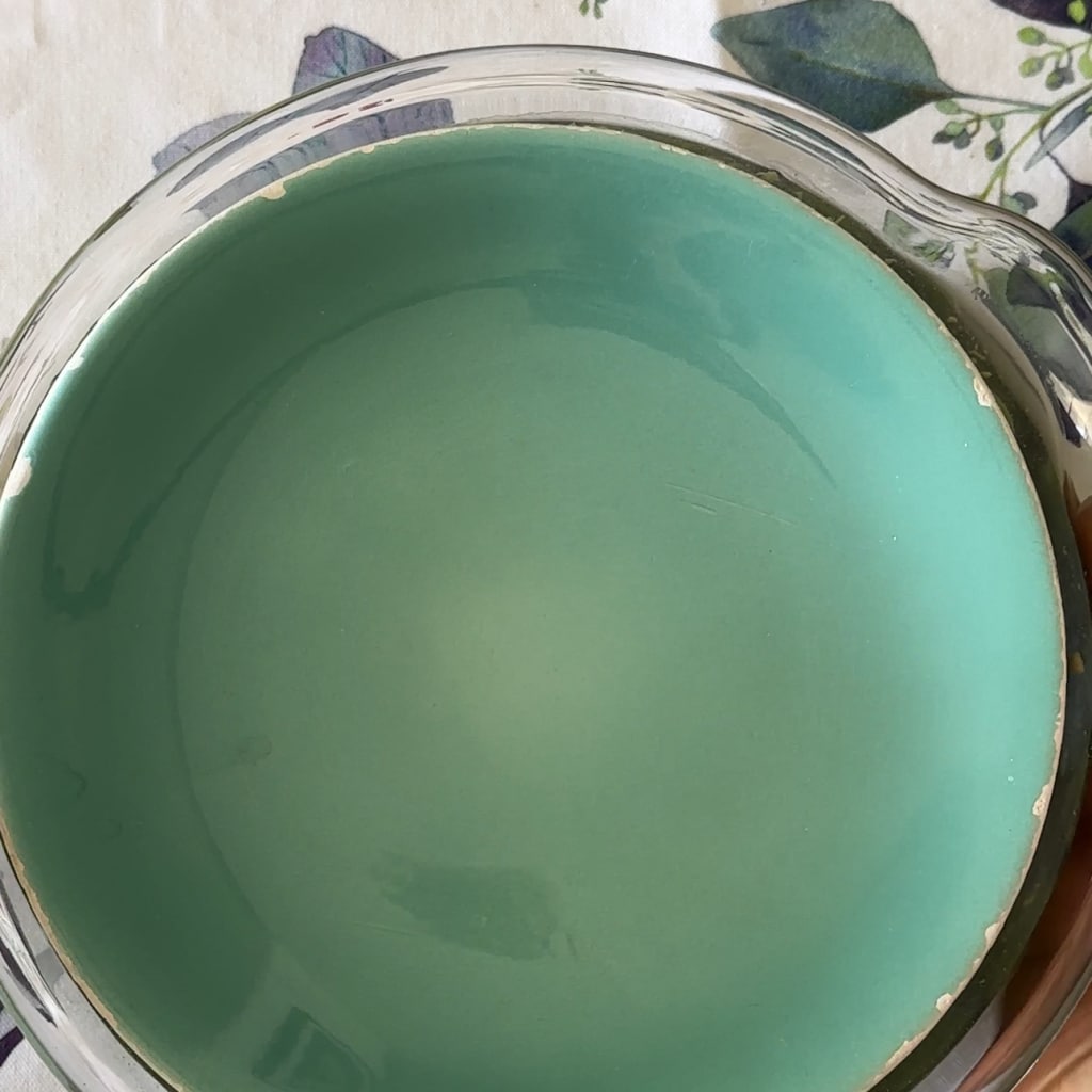 place a plate over the olives with water to keep them submerged