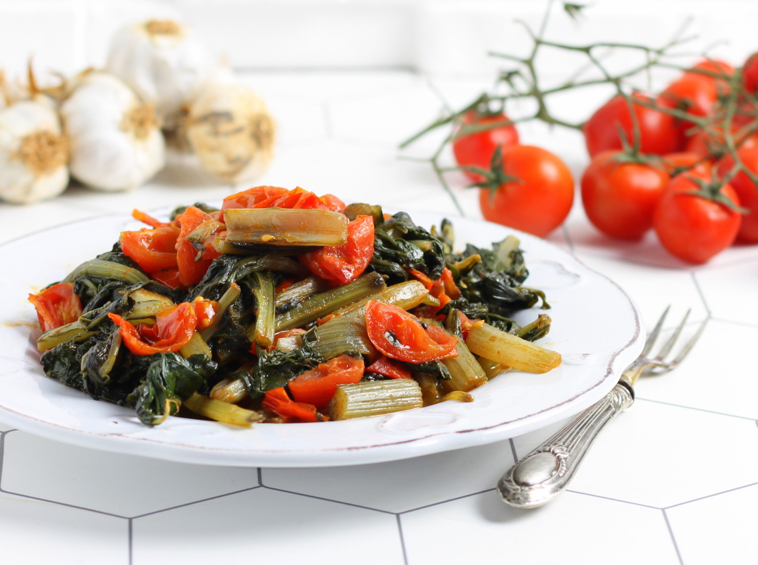 Chard sautéed in a pan with garlic and cherry tomatoes