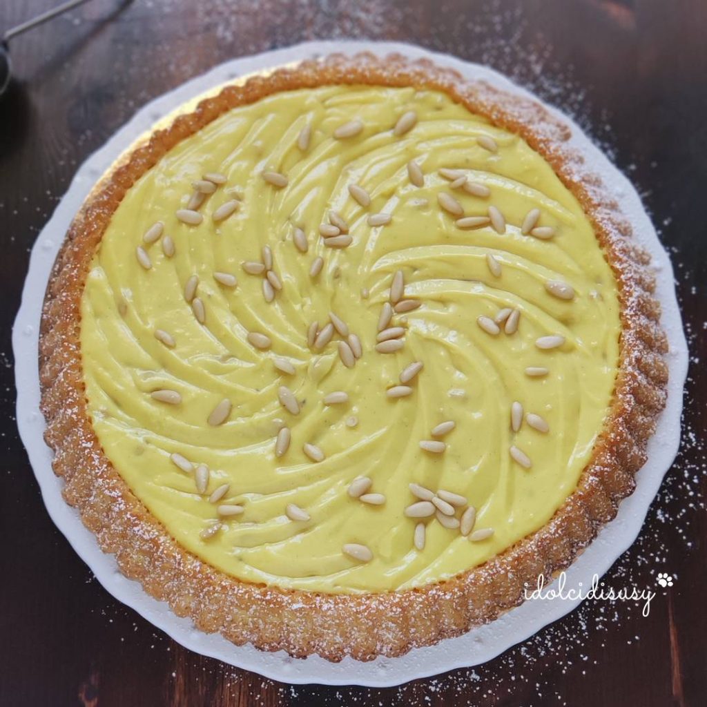 soft grandma's tart with yellow cream decorated with pine nuts