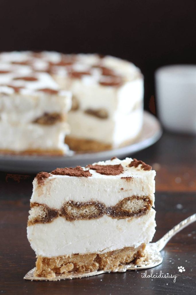Slice of egg-free tiramisu cheesecake with a layer of ladyfingers and cocoa