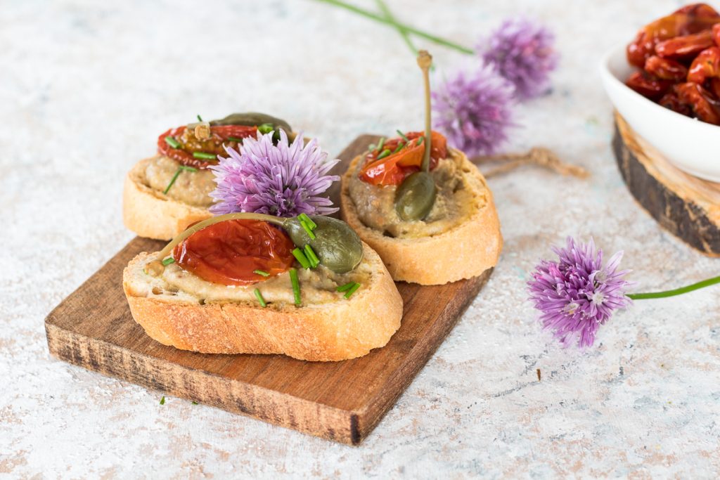Crostini with chickpea hummus, tomatoes, and capers