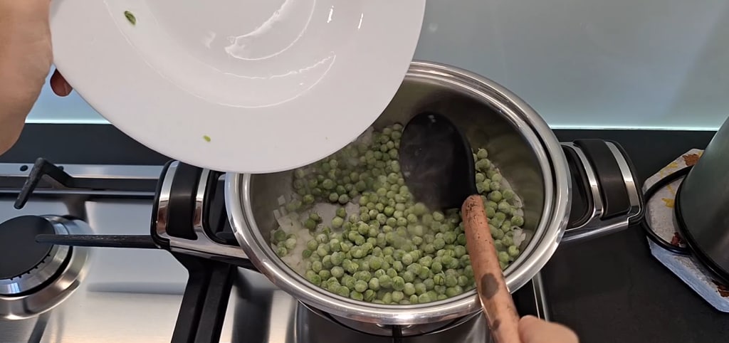 Peas added to the pot with sautéed onion