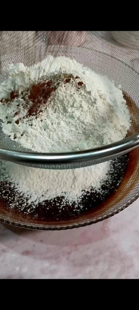 Adding flour, cocoa, and baking powder to the batter