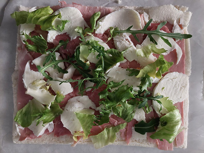 Sandwich roll with rolled white bread and ham