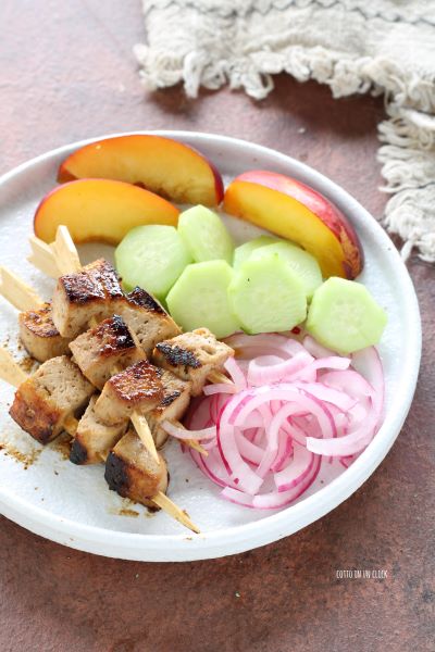 squeeze the onion and place it on the plate with the skewers, cucumber, and peach slices