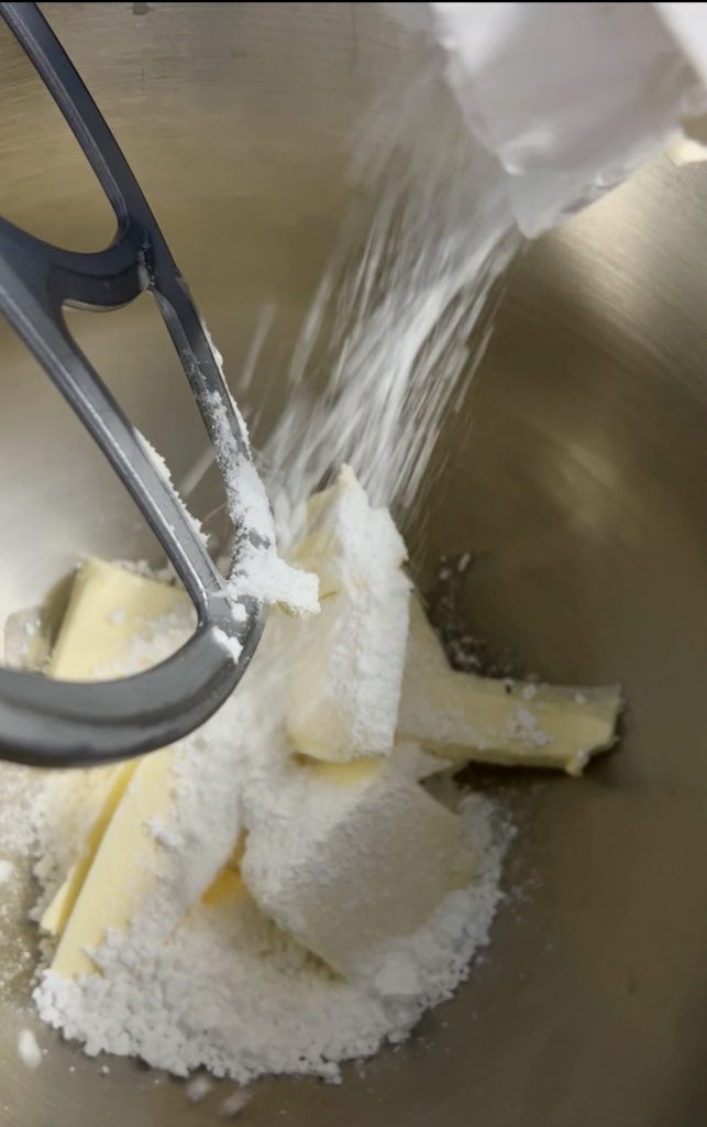Butter and powdered sugar whipped in a bowl to prepare the whipped shortbread cookie dough