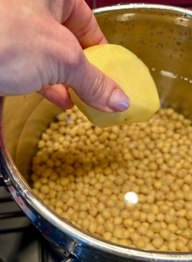 Chickpeas in a pot with potato and herbs for creamy pasta and chickpeas
