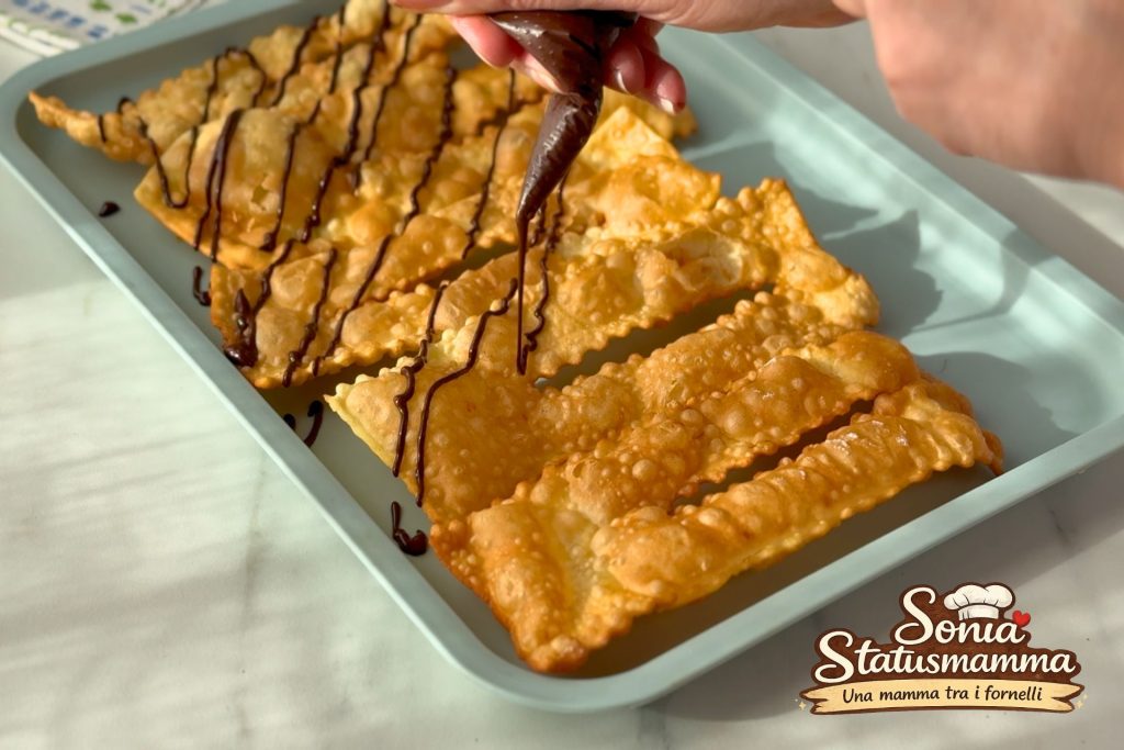 Tray of crispy Carnival fritters with bubbles and a thin dark chocolate drizzle