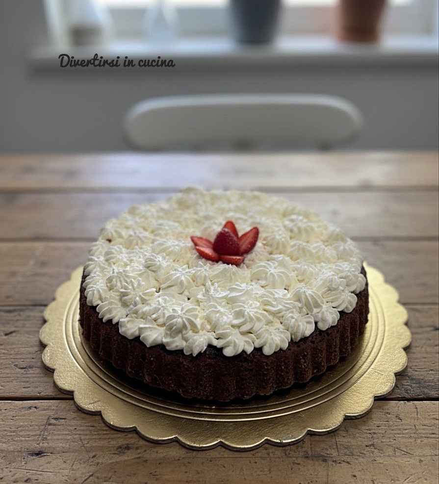 Soft cocoa tart decorated with dollops of whipped cream and mascarpone and a fresh strawberry in the center, served on a golden tray