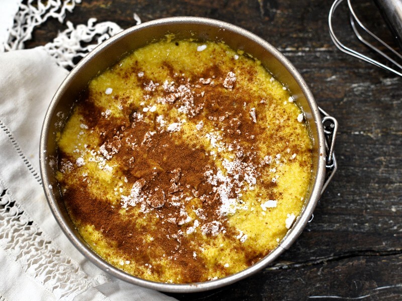 Round pan with Ultra-Soft Butter Cake batter, dusted with cinnamon, ready to bake