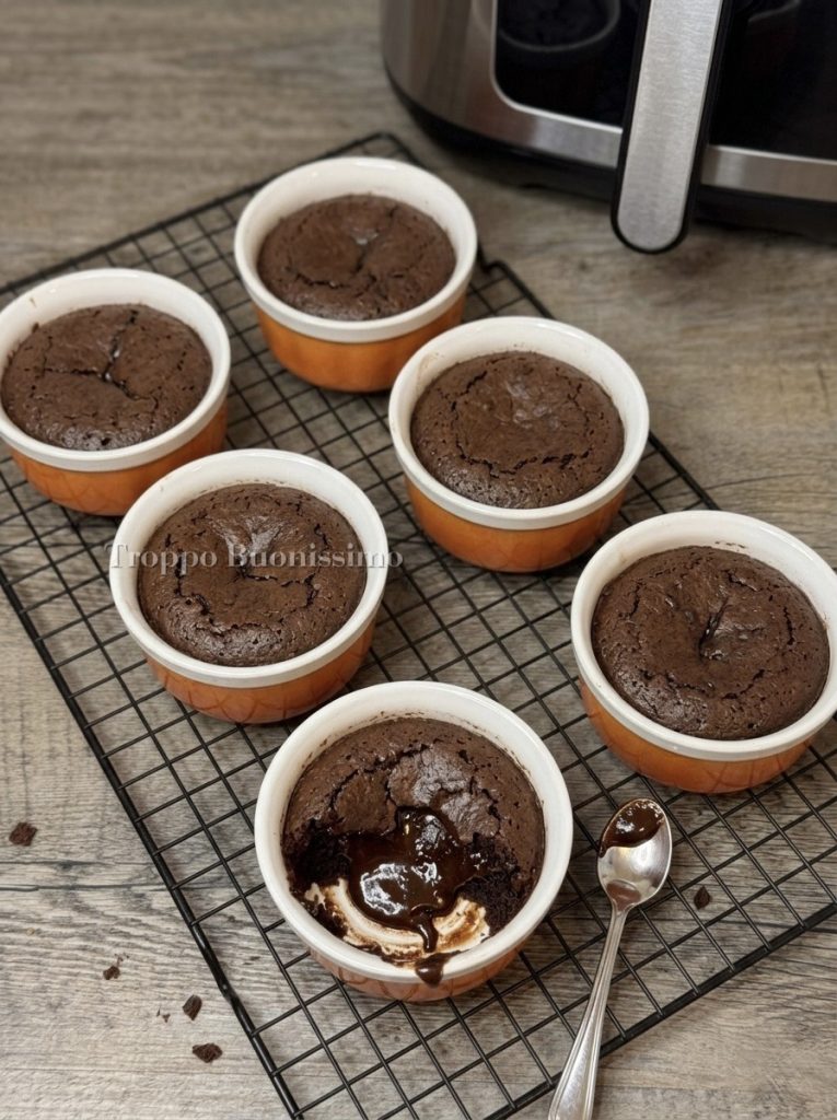 Dark chocolate molten lava cake with a flowing center cooked in an air fryer on a black rack