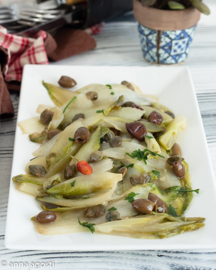 Belgian endive stewed in a skillet with olives