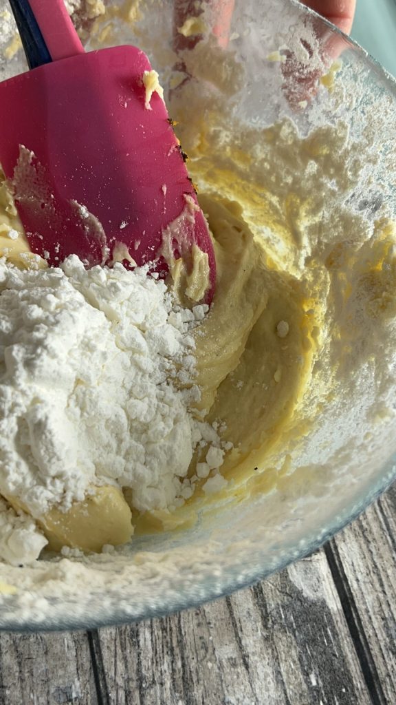 Soft dough of the orange cookies mixed with a spatula