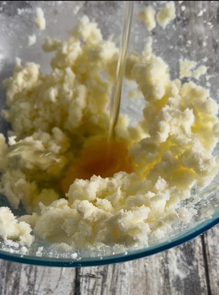 Egg added to beaten butter to prepare soft orange cookies