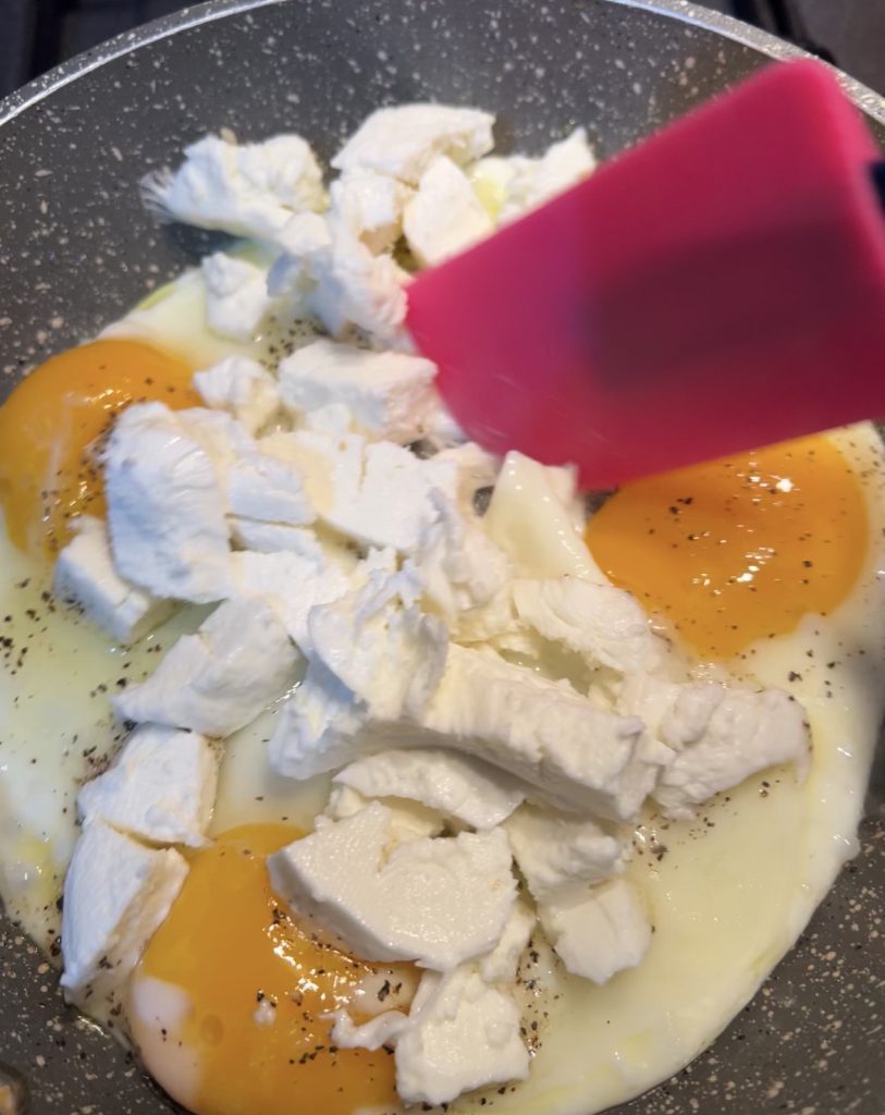 adding mozzarella to scrambled eggs