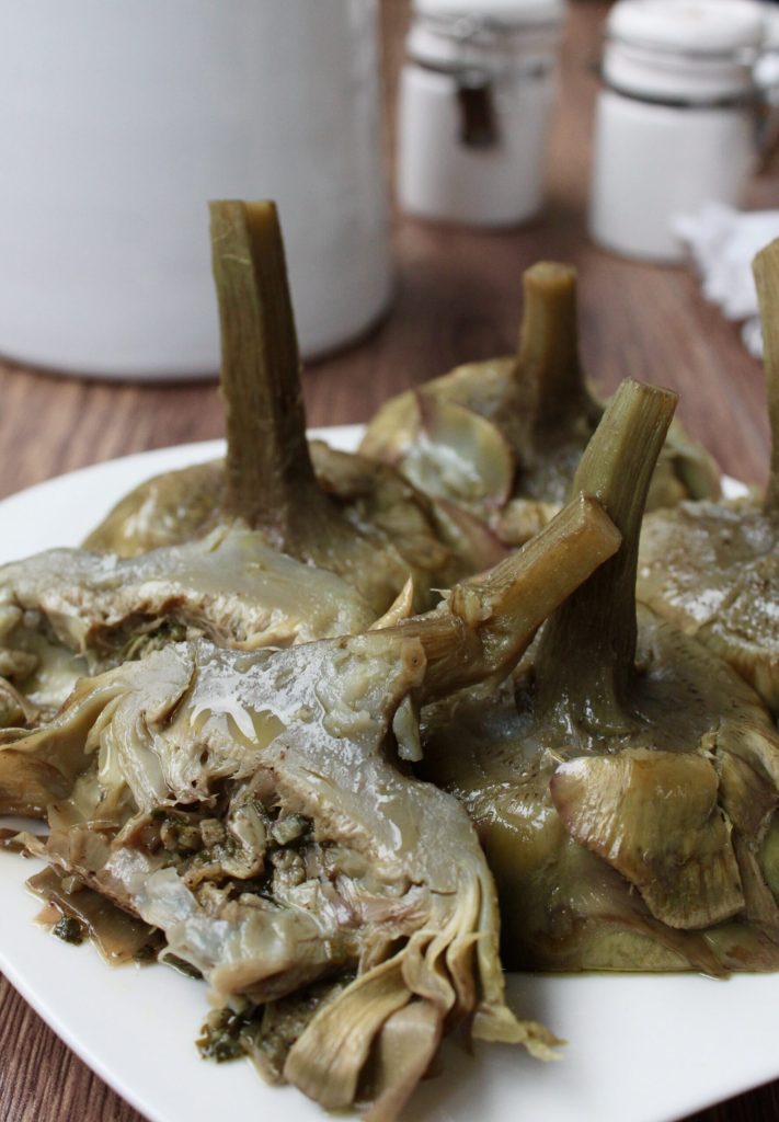 tender and fragrant Roman-style artichokes with visible stuffing cooked in a pan