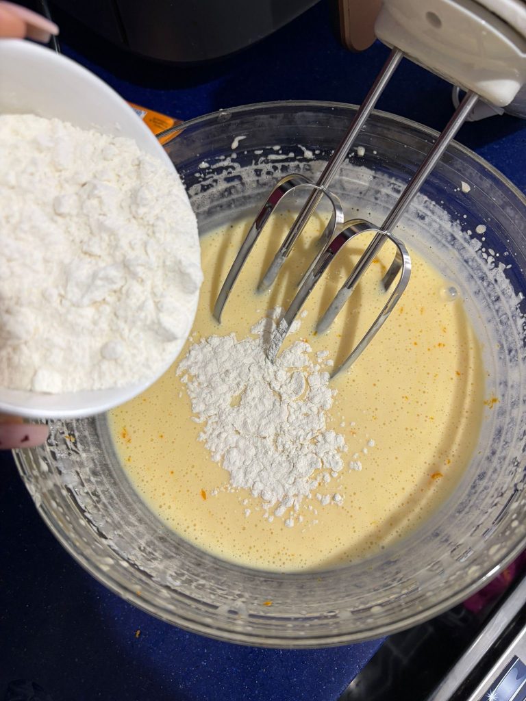 adding the flour to the batter of the ricotta and orange ring cake