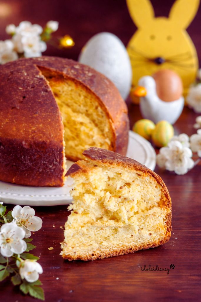 Slice of tall, soft Easter sweet pizza with an alveolated interior on a rustic table.