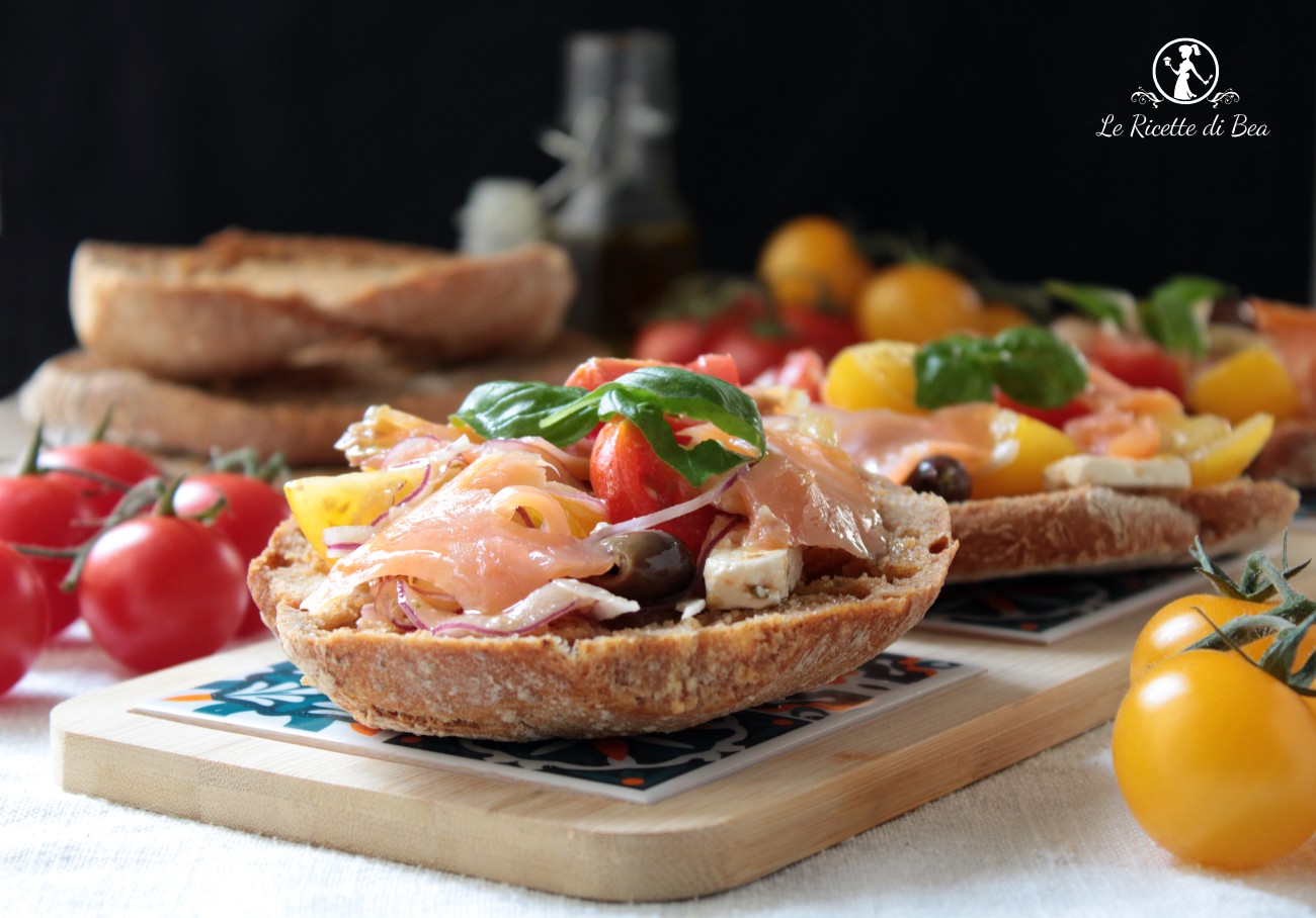 Friselle with smoked salmon, cherry tomatoes, red onion, Taggiasca olives and feta