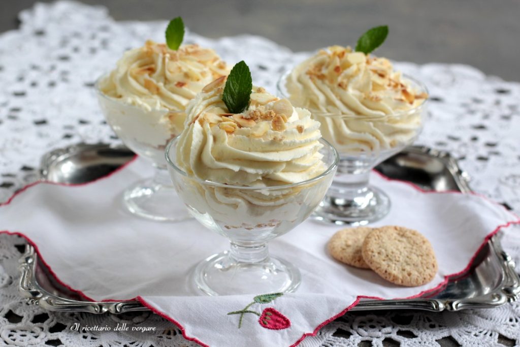 Three cups of no-bake lemon cream decorated with mint and almonds on a silver tray