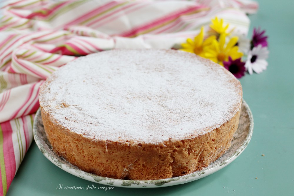 Whole Margherita cake, very tall and soft, dusted with powdered sugar on a tray.