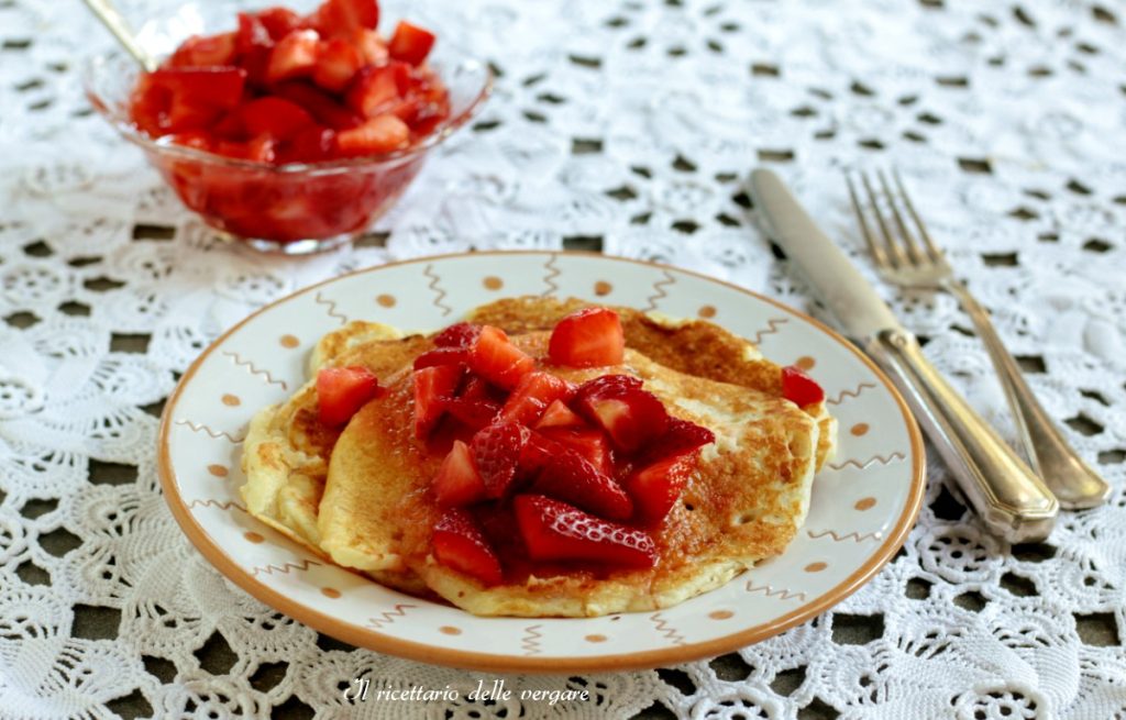 Stack of fluffy coconut cream pancakes without eggs with diced strawberries