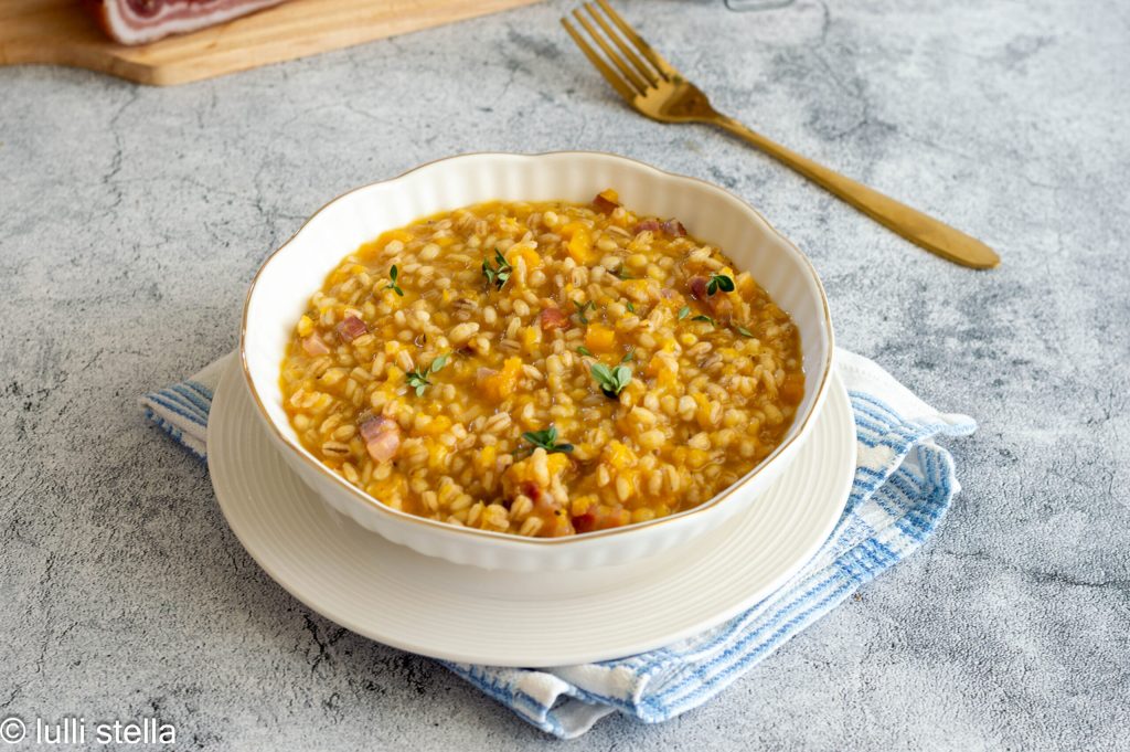 Close-up of pearl barley with pumpkin cubes and golden speck