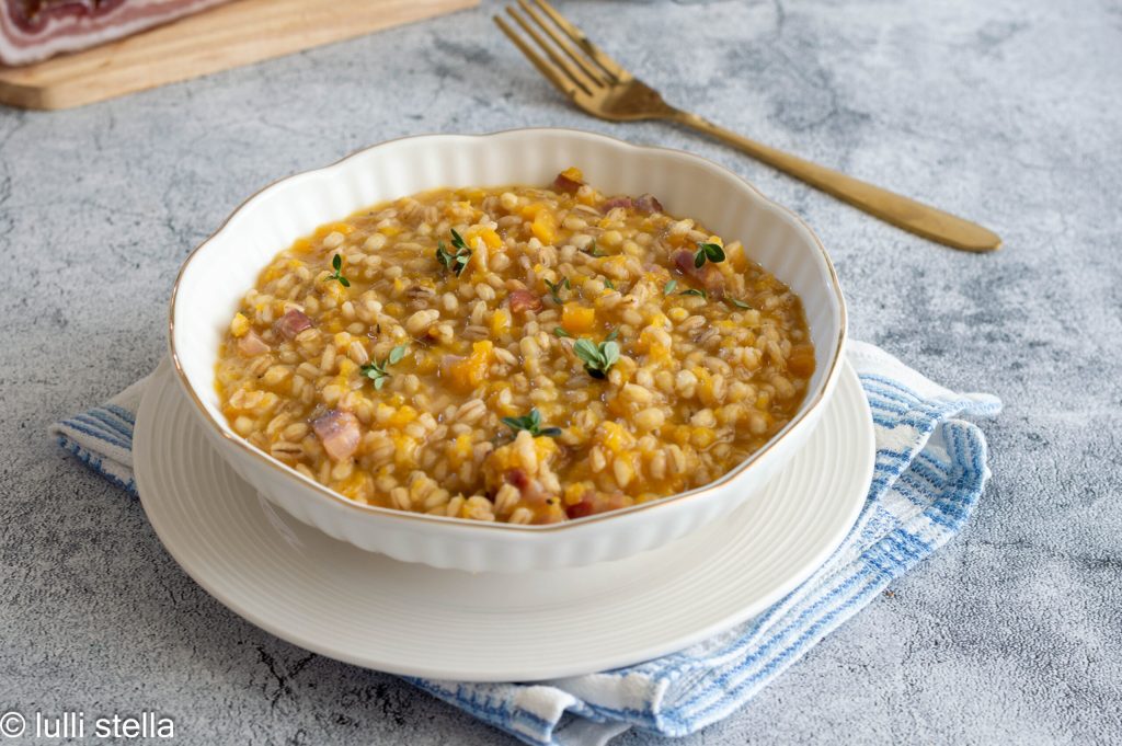 Close-up of pearled barley with pumpkin cubes and golden speck