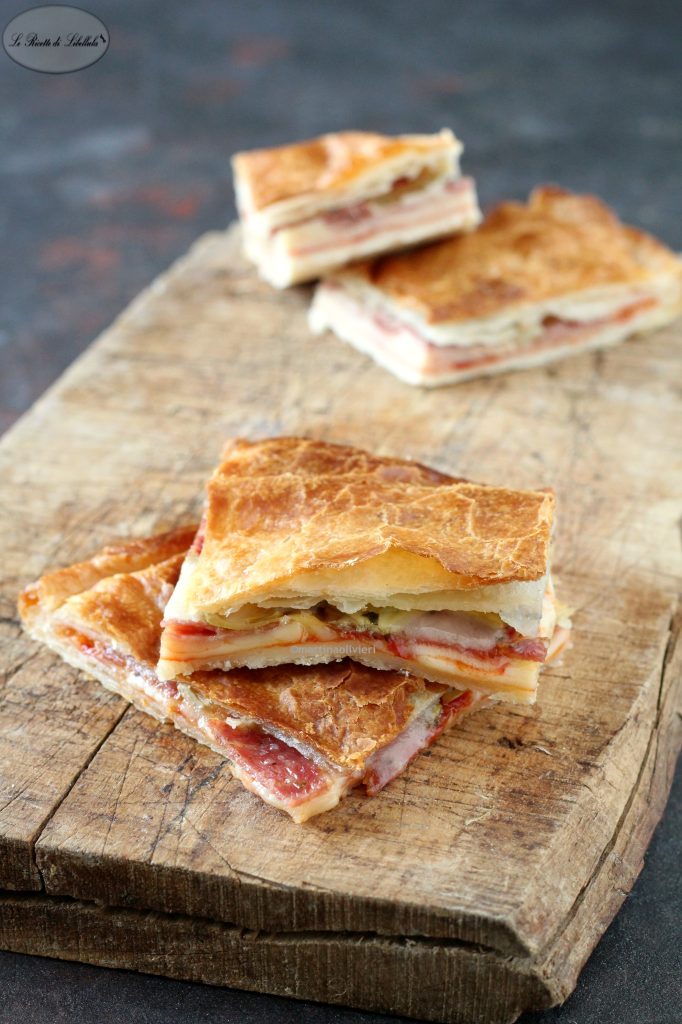 Puff pastry savory pie with salami and artichokes